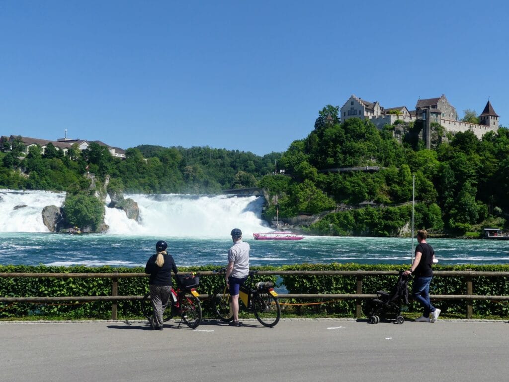 A group of cyclists looking at the Rhine falls (Black Forest)