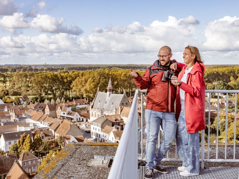 2 touristes en train d'admirer la vue depuis le clocher de Damme